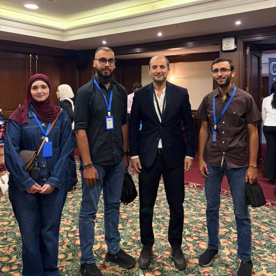 أعضاء النادي الرياضي في الجامعة العالمية مع أحد ممثلي الجامعة خلال المؤتمر