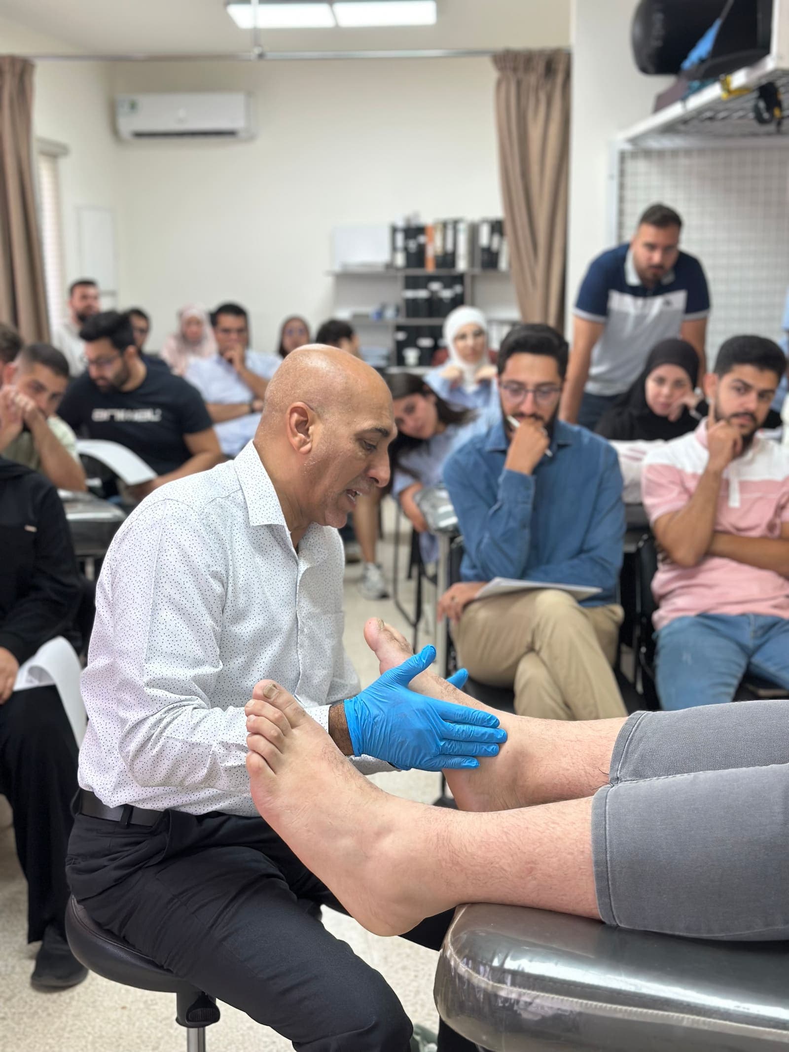 Dr. Hussein Nasser demonstrates a Mulligan manual therapy technique to physical therapy students at the Global University Health Center