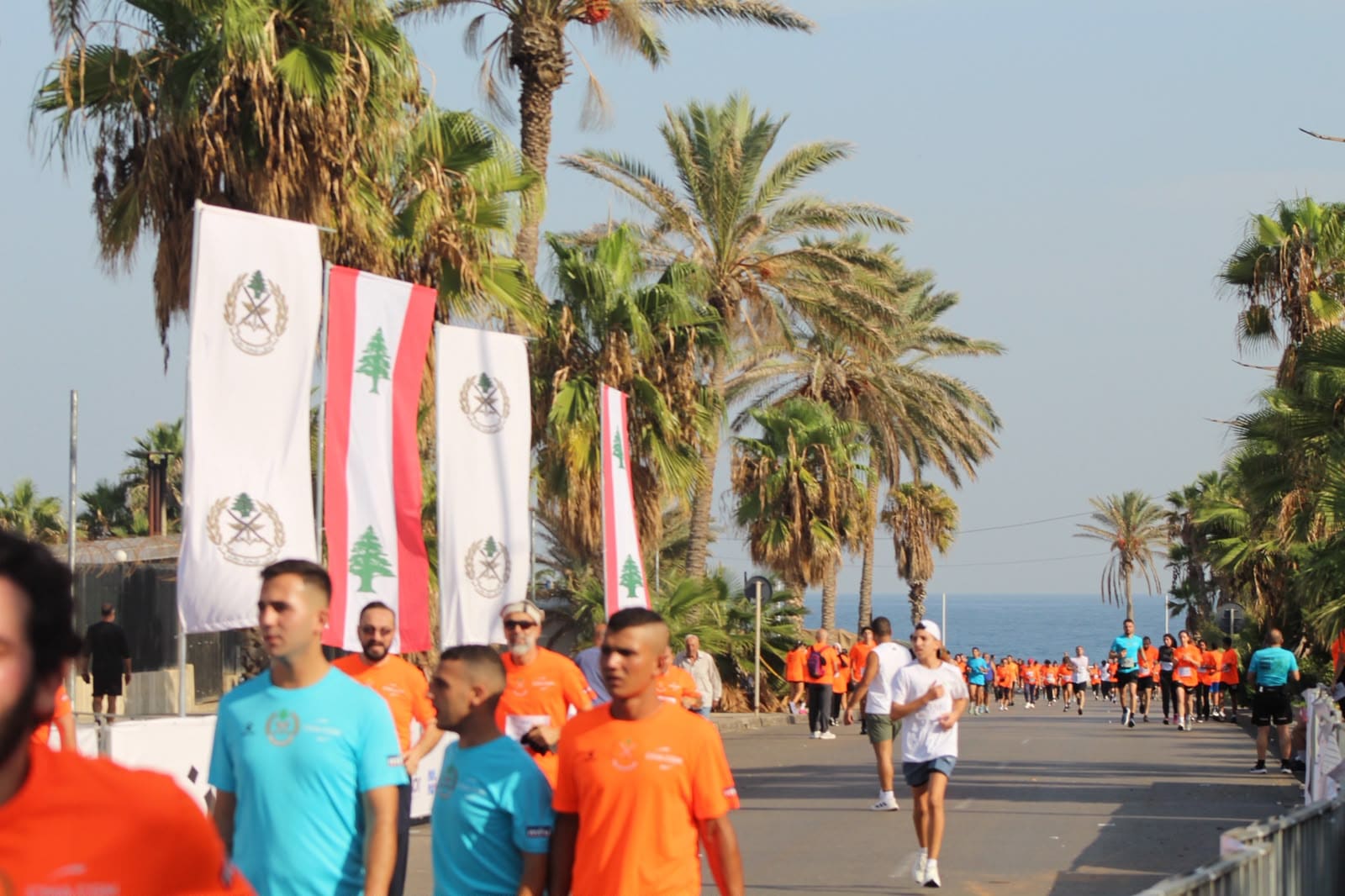 مشاركون في الماراثون على الكورنيش بجانب أعلام لبنان