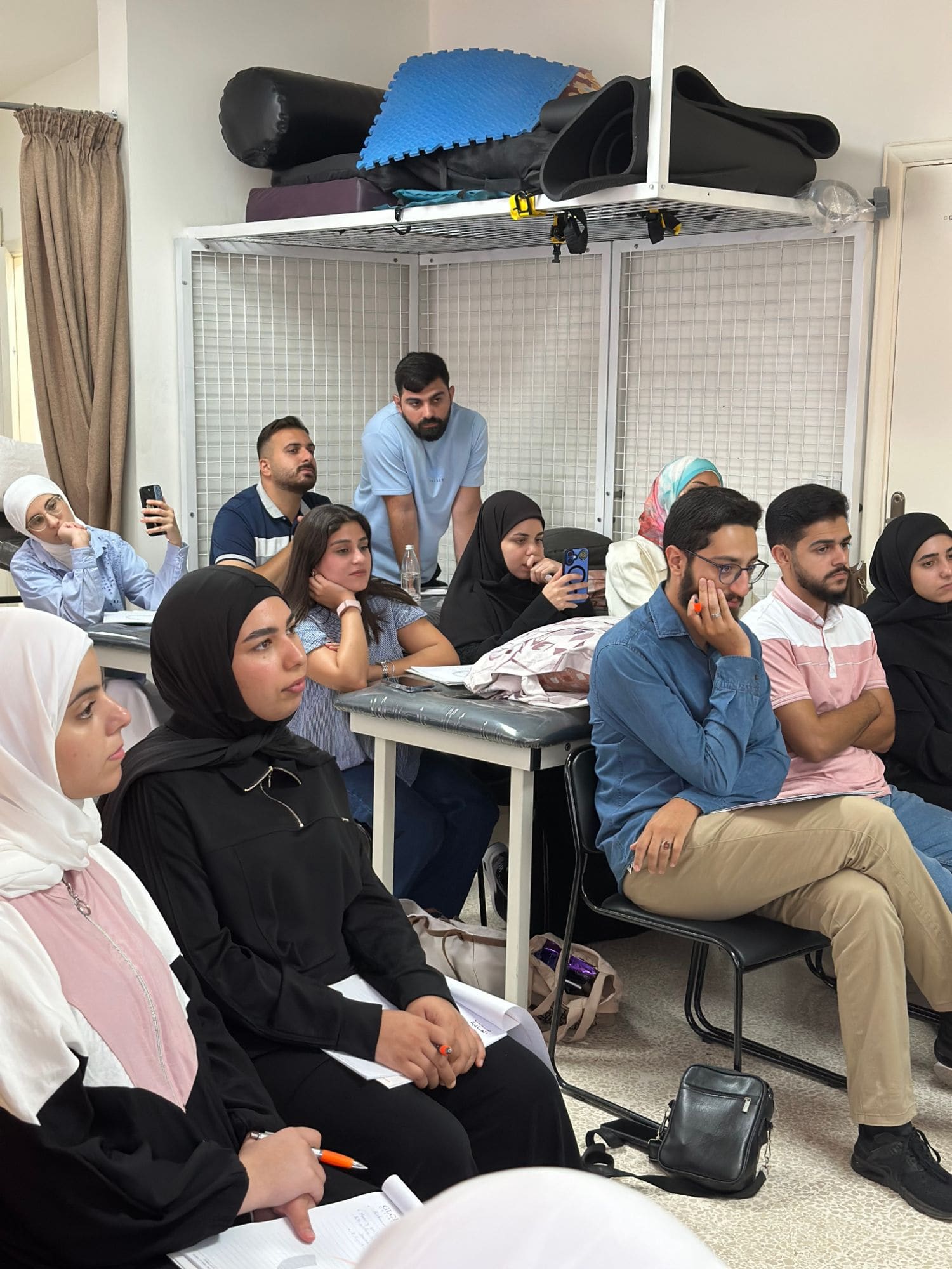 Workshop participants seated and listening attentively during a classroom session